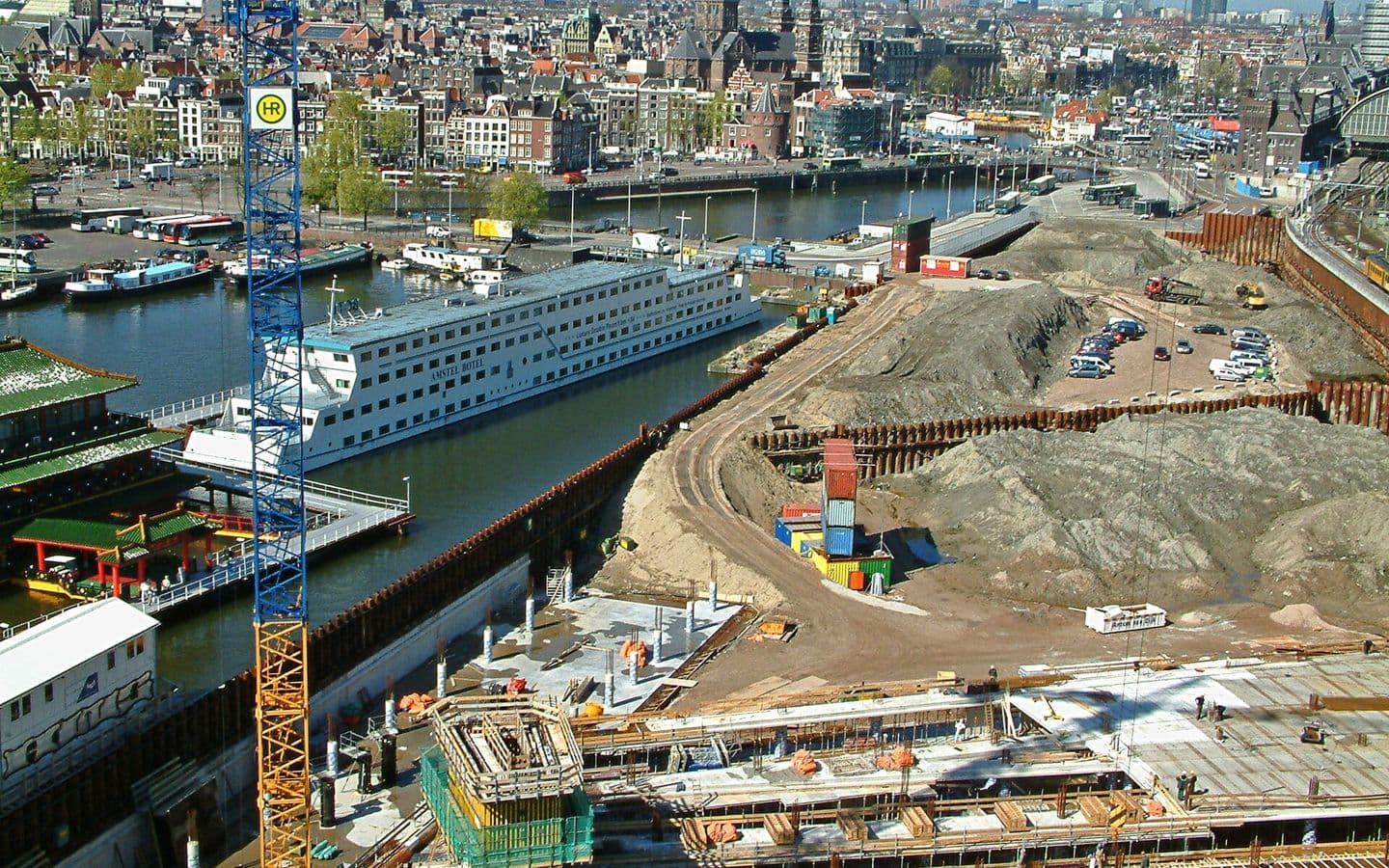 Aerial view of a large urban construction site with cranes and excavation