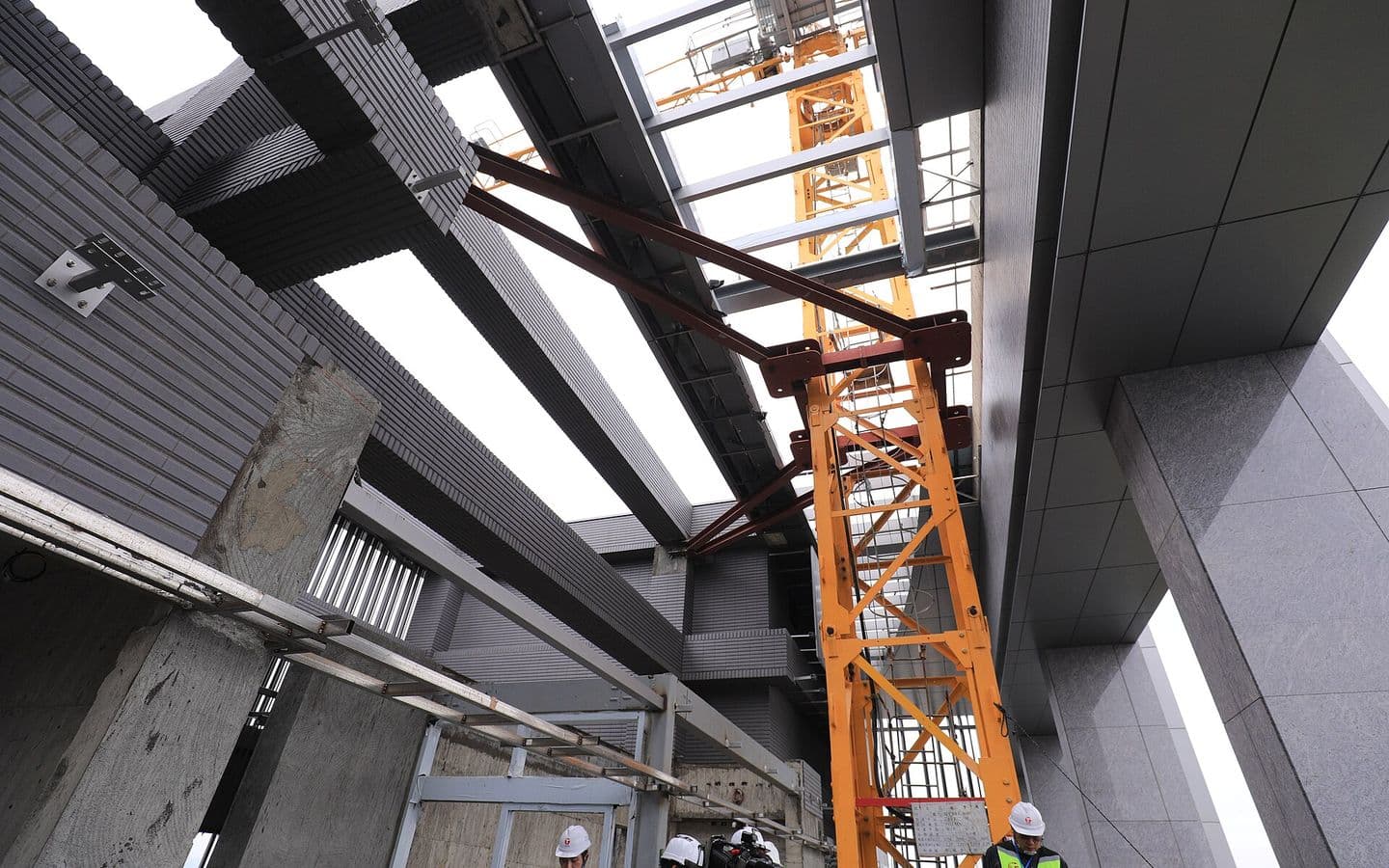 Steel structure under construction with a tower crane overhead